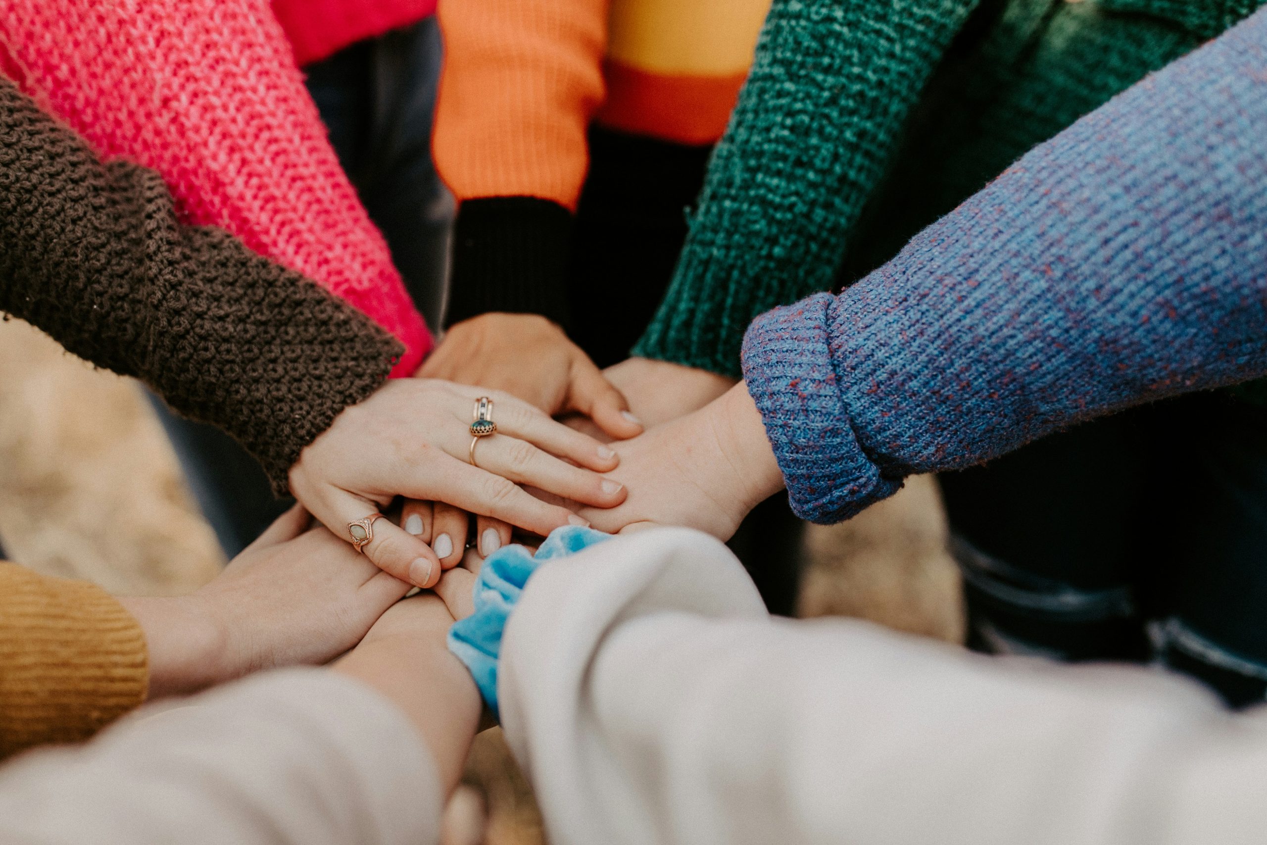 Close-up of a group of hands stacked in a circle on top of each other.